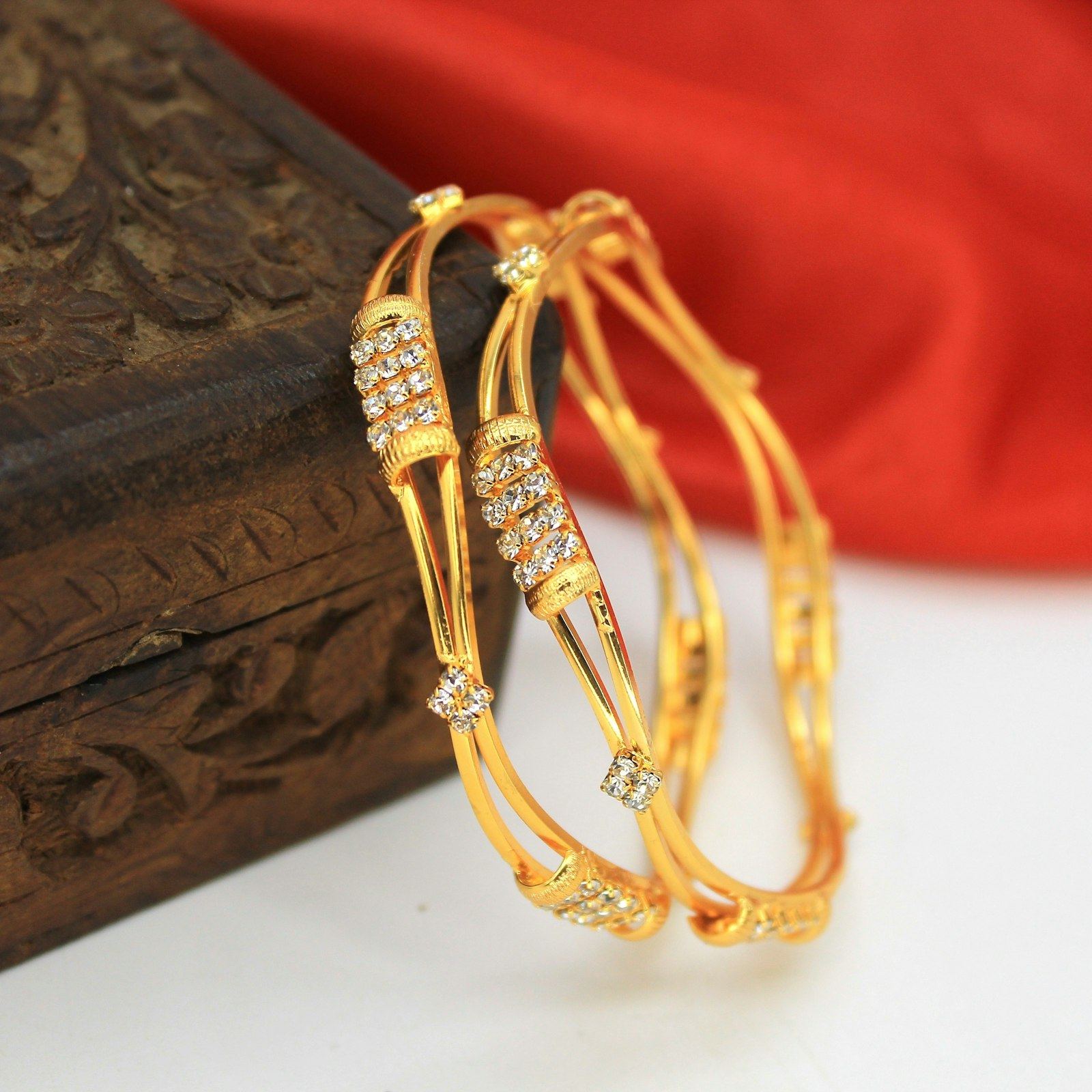 Gold bangles resting on a carved wooden box